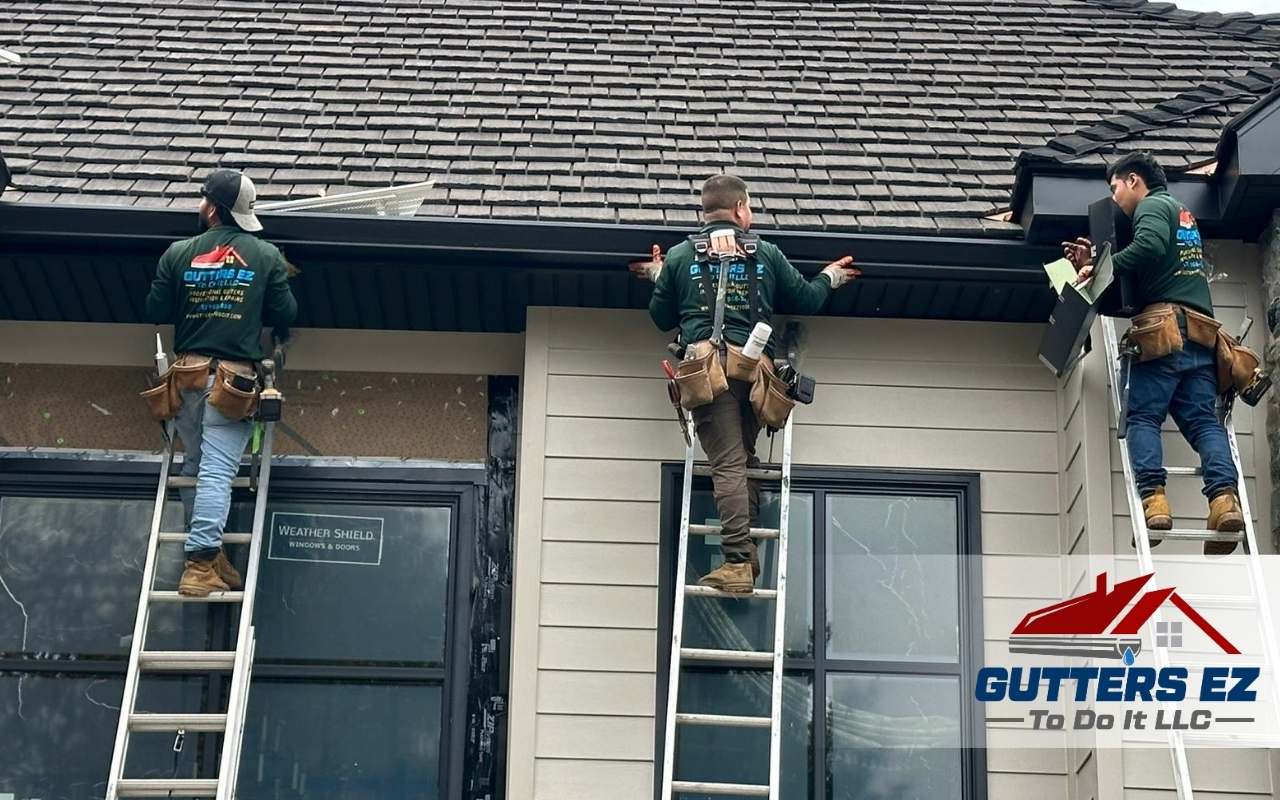 Technician carefully removing old gutters from a house roof.