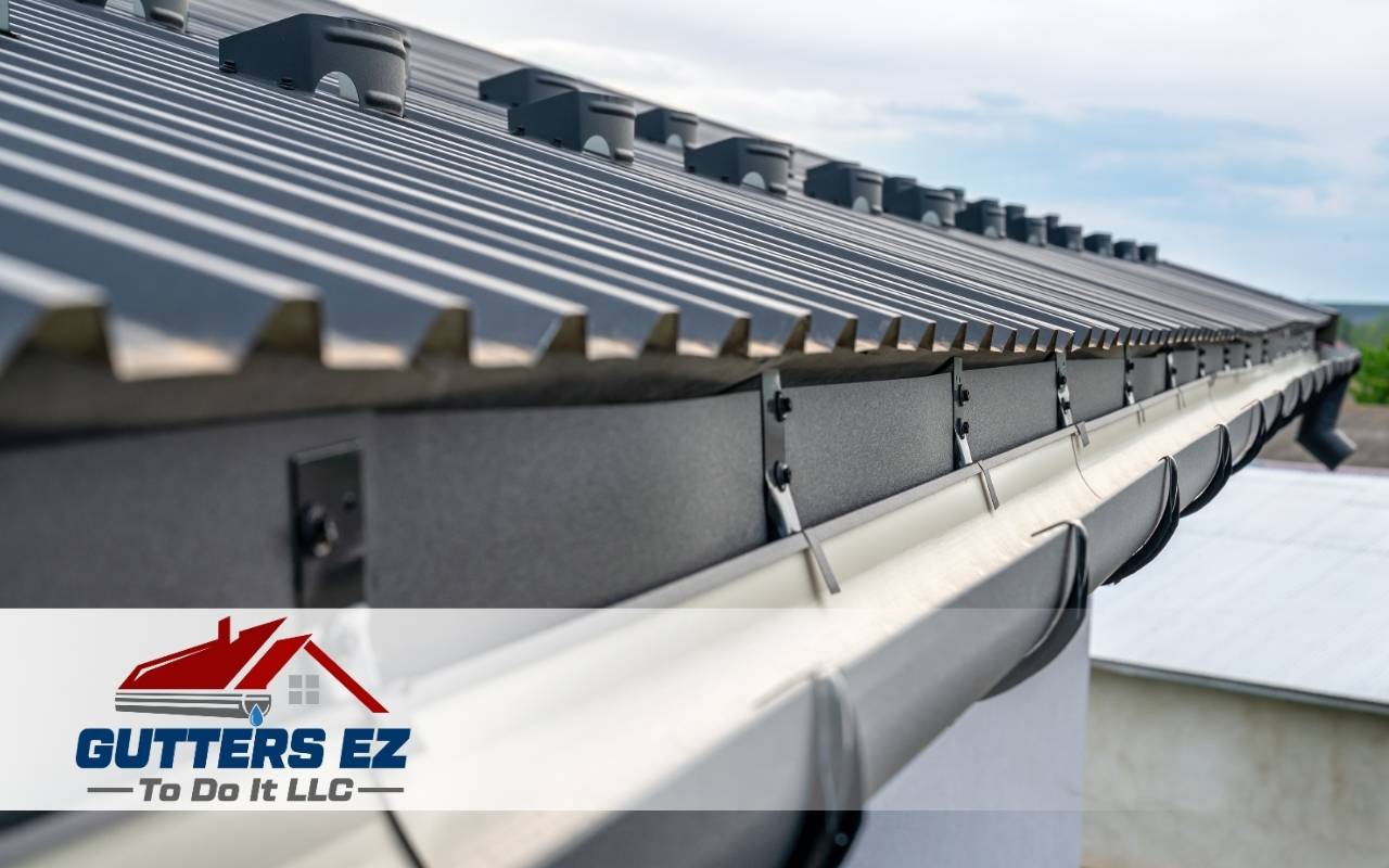 Vinyl gutters installed on a residential home with light siding
